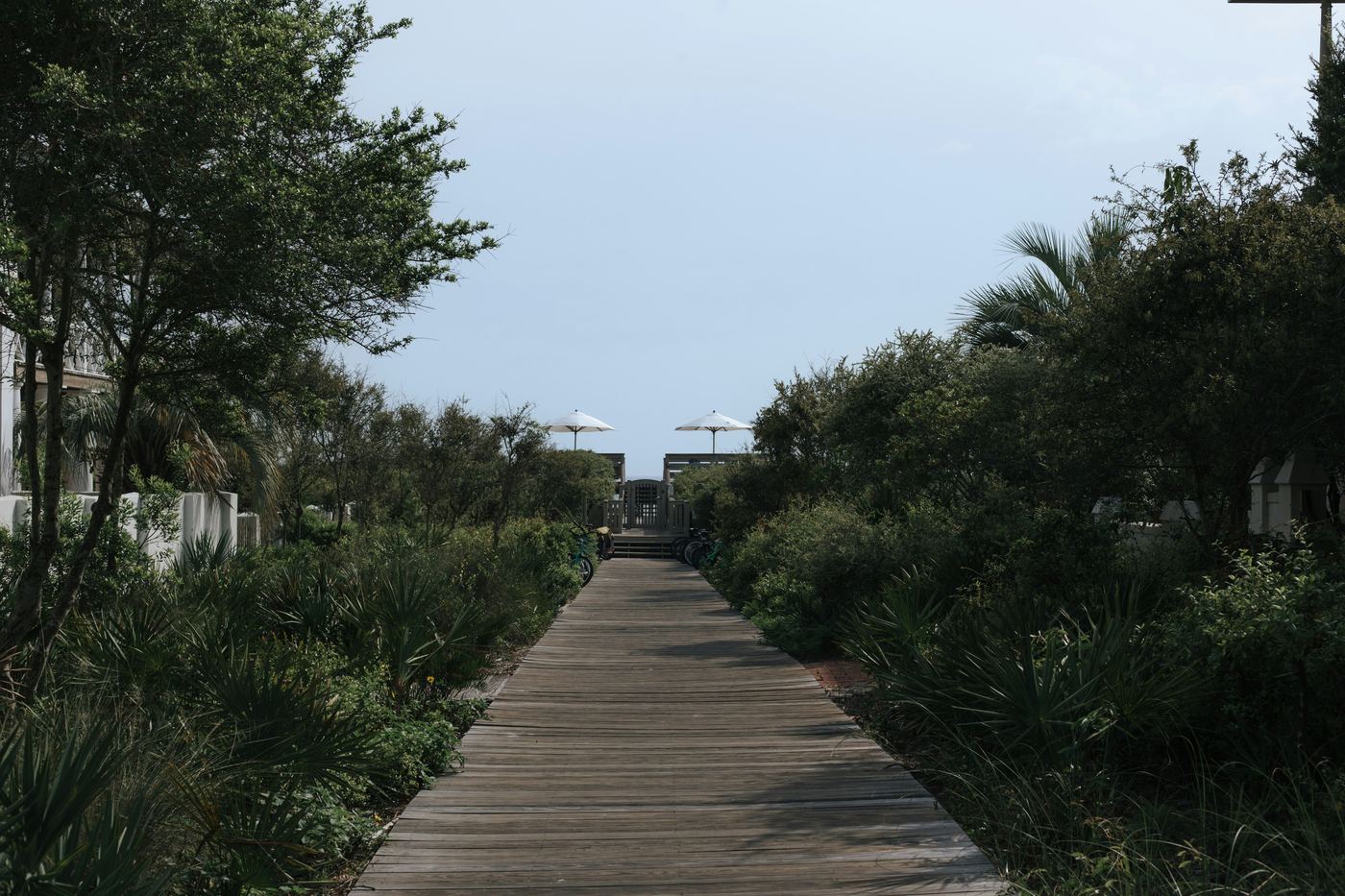 Wooden boardwalk leading to a beach lined with umbrellas
