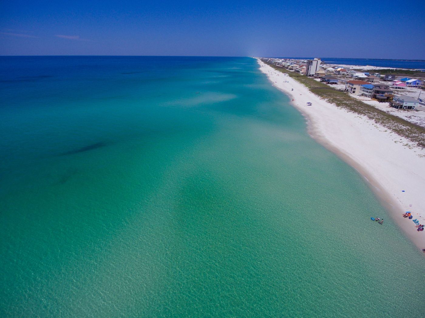 Emerald-green Gulf water along a white-sand Florida Panhandle beach
